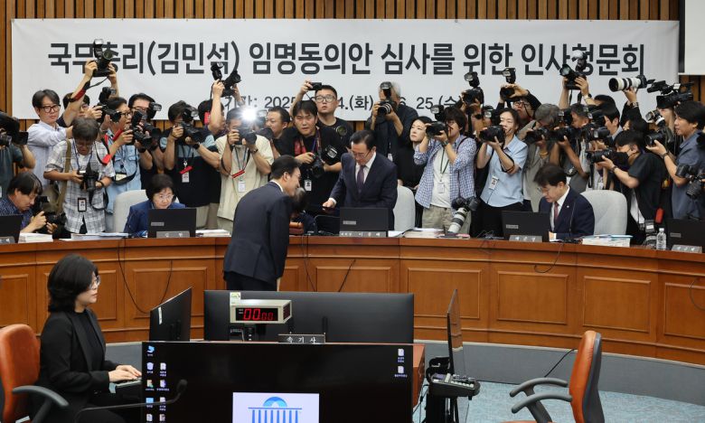 김민석 국무총리 후보자가 24일 서울 여의도 국회에서 열린 인사청문회에서 총리 후보자 인사청문특별위원회 위원장인 국민의힘 이종배 의원에게 선서문을 제출한 뒤 인사하고 있다. 연합뉴스