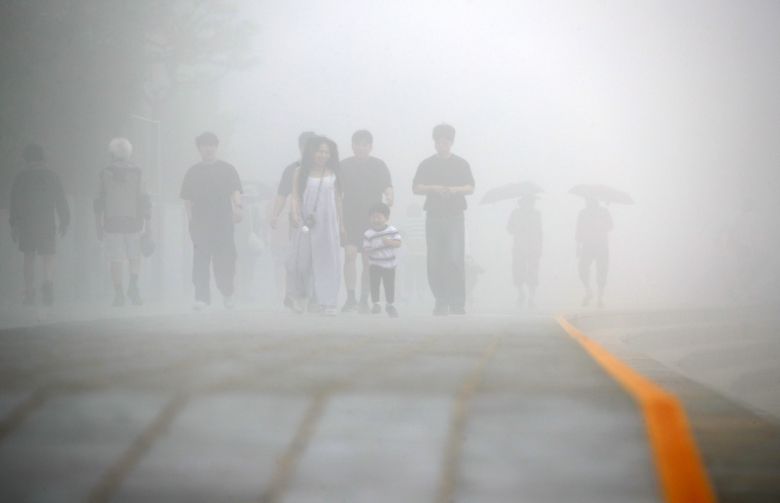 지난 20일 부산 해운대해수욕장을 찾은 관광객들이 뿌옇게 낀 안개 사이를 거닐고 있다. 사진 = 뉴스1