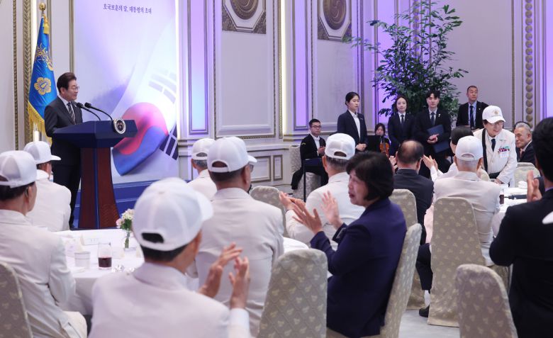 이재명 대통령이 27일 청와대 영빈관에서 열린 '호국 보훈의 달, 대통령의 초대' 행사에서 6·25전쟁에 참전해 유격대원으로 활약했던 여성 참전유공자 이춘자 참전용사를 소개하고 있다. 연합뉴스