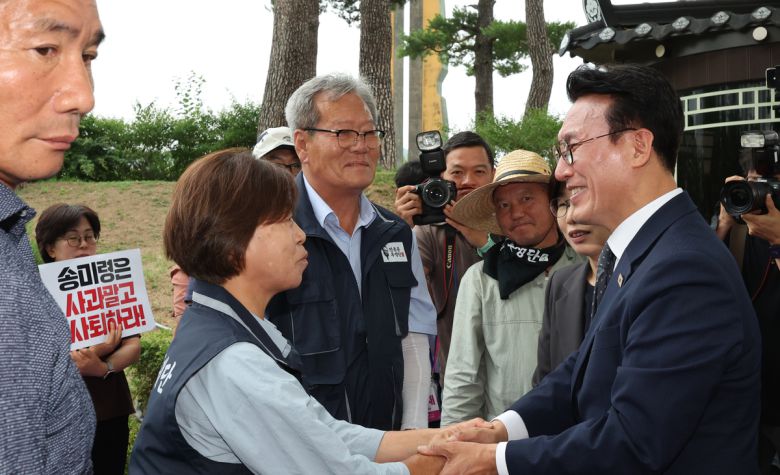 4일 김민석 국무총리가 서울 용산 대통령실 앞에서 항의 집회 중인 농민단체와 악수하고 있다. 이들 단체는 '농업4법'을 '농망4법'이라고 했던 송미령 농림축산식품부 장관의 유임을 반대하며 송 장관이 물러날 때까지 투쟁을 멈추지 않겠다고 예고한 상태다. 연합뉴스