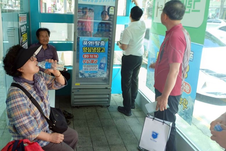 전북 고창군 한 무더위 쉼터에 비치된 양심냉장고에서 주민들이 생수로 더위를 식히고 있다. 고창군 제공