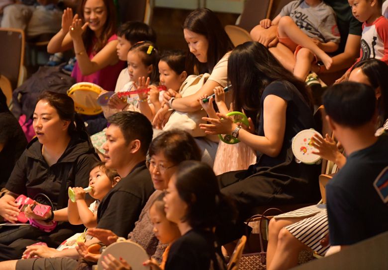 어린이 관객이 오케스트라와 함께 합주하는 장면.