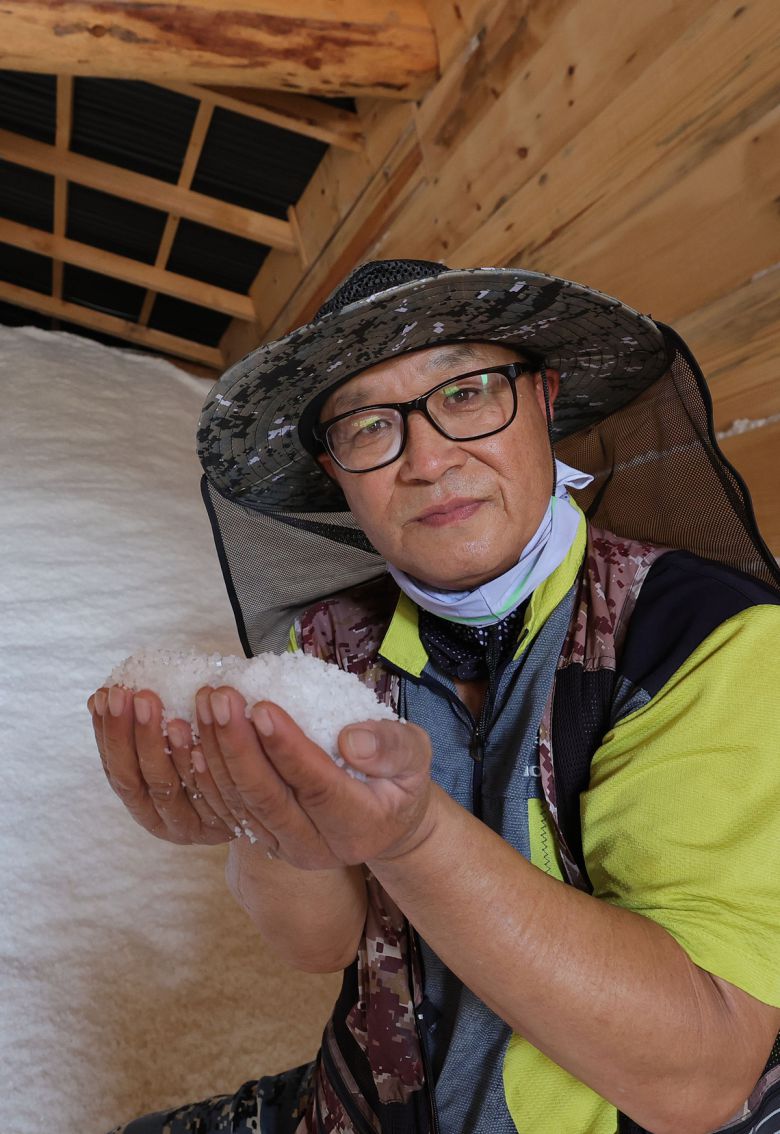 염부 전동길 씨가 소금창고에서 수확한 소금을 들어보이고 있다.