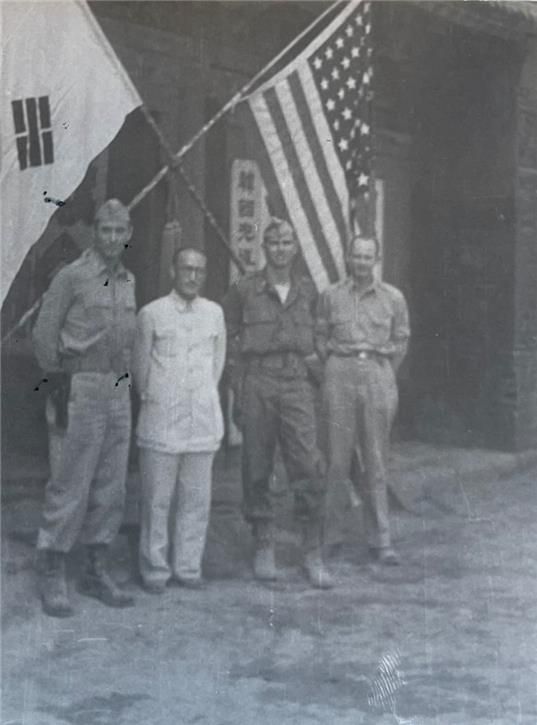 이범석 장군(왼쪽 두 번째)과 OSS 장교들이 태극기와 성조기를 배경으로 찍은 사진이다. 뒤에는 ‘한국광복(군)’으로 시작하는 현판이 보인다. 1945년 초에 촬영된 것으로 추측된다. 국사편찬위원회 제공