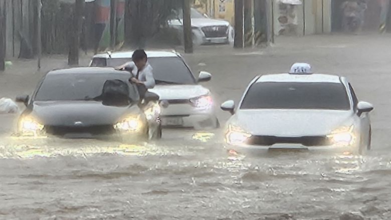 광주지역에 시간당 86㎜ 폭우가 쏟아진 17일 오후 광주 북구청 앞 교차로에서 한 운전자가 침수 차량에서 탈출을 시도하고 있다. 뉴시스