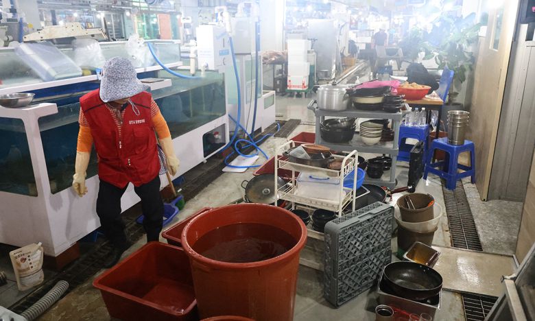 지난 18일 오전 집중호우로 침수된 충남 당진시 읍내동 당진어시장에서 한 상인이 침수 피해를 본 집기류를 세척하고 있다. 연합뉴스
