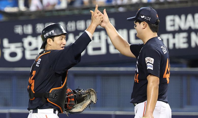 프로야구 한화 마무리 투수 김서현(오른쪽)과 포수 최재훈이 지난 22일 서울 잠실구장에서 열린 두산과 경기에서 승리해 10연승을 기록한 뒤 세리머니를 하고 있다. 연합뉴스