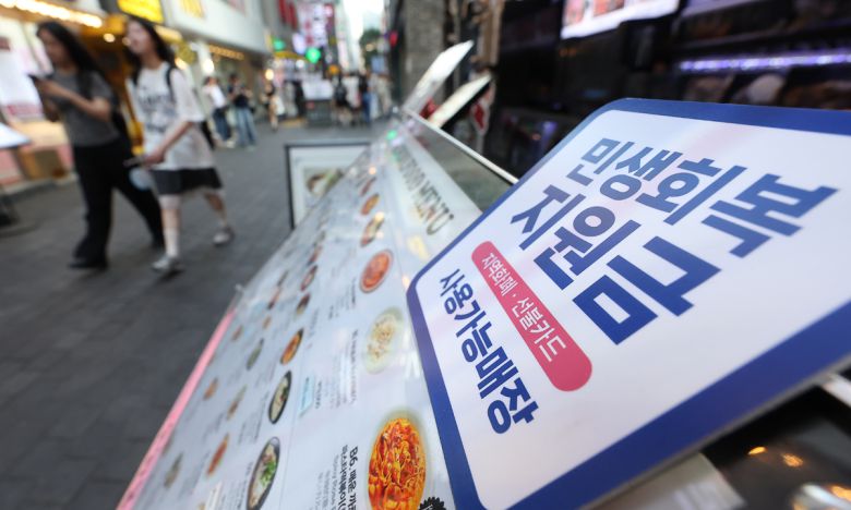 지난 24일 서울 시내 한 음식점 메뉴판에 민생회복 지원금 안내문이 붙어 있다. 연합뉴스