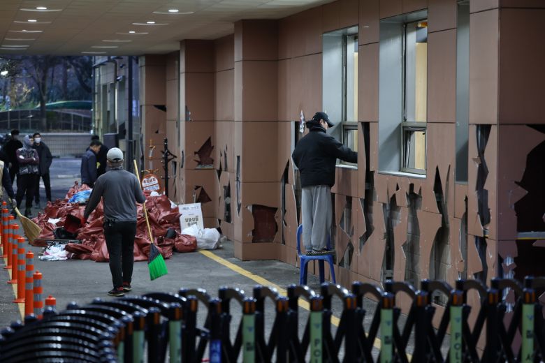 지난 1월19일 윤석열 대통령 지지자들의 폭력 난입 사태가 발생한 서울 마포구 서울서부지방법원에서 관계자들이 파손된 유리창 등 폐기물을 치우고 있다. 뉴스1