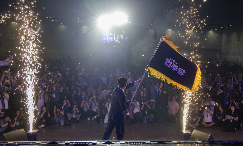 더불어민주당 정청래 신임 당대표가 2일 고양 킨텍스에서 열린 전국당원대회에서 김병기 당대표 직무대행 겸 원내대표로부터 받은 당기를 흔들고 있다. 연합뉴스