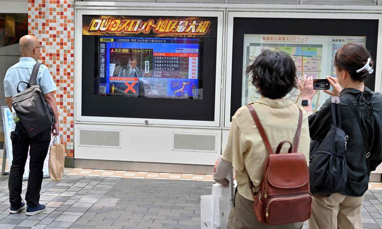 지난 7월 30일(현지시간) 러시아 동부 해상에서 규모 8.7의 지진이 발생해 일본 해안 대부분 지역에 쓰나미 경보가 발령됐다. 사진은 일본 도쿄 중심부의 한 게임샵 밖에서 지나가던 사람들이 걸음을 멈추고 뉴스를 보고 있는 모습. AFP연합뉴스