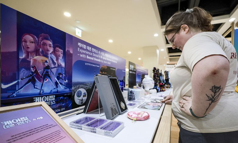 12일 서울 종로구 서울마이소울샵에 마련된 '케이팝 데몬 헌터스' 테마의 서울굿즈존'을 찾은 외국인 여행객들이 제품을 살펴보고 있다. 뉴시스