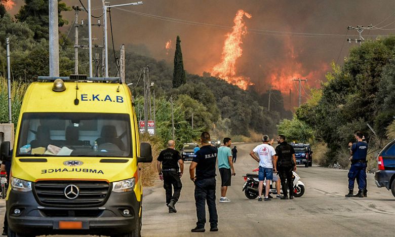 12일 파트라 인근 숲에 발생한 산불을 시민들이 바라보고 있는 모습. 파트라=AFP연합뉴스