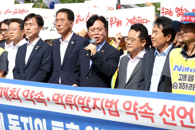 29일 경북 구미시 한국옵티칼하이테크 공장 지붕에서 고공농성을 이어온 박정혜 금속노조 한국옵티칼하이테크지회 수석부지회장이 땅으로 내려오기에 앞서 열린 현장 기자회견에서 김영훈 고용노동부 장관이 발언하고 있다.    연합뉴스