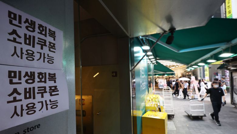 서울 중구 명동 상점에 민생회복 소비쿠폰 관련 안내문이 붙어 있다. 뉴시스