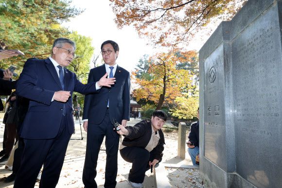 최휘영 문화체육관광부 장관과 허민 국가유산청장이 7일 역사문화환경 보존지역 바깥에서의 개발 규제 완화 조례에 대한 대법원 판결과 관련해 서울 종묘를 방문한 뒤 유네스코 세계유산 기념비석을 바라보고 있다. 연합뉴스