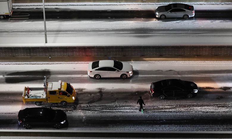 4일 서울 서대문구 홍제동 내부순환로에서 차량이 얼어붙은 눈길에 서행하는 가운데 내부순환로에서 시설관리공단 관계자가 제설 작업을 하고 있다. 연합뉴스
