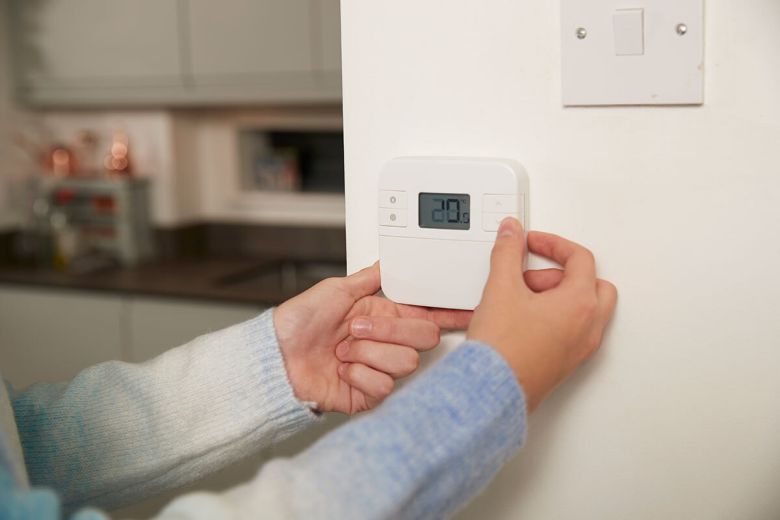 집안 벽면에 설치된 온도 조절기를 사용해 난방 온도를 설정하는 모습. 클립아트코리아