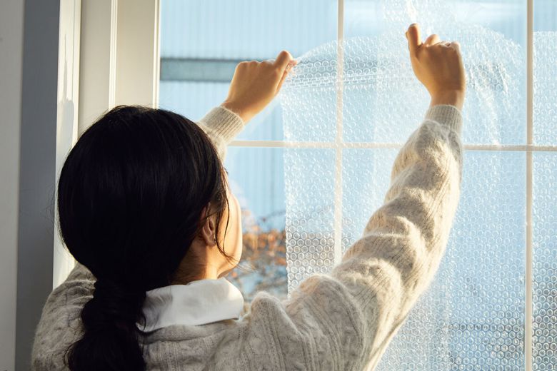 주거 공간의 열 손실을 줄이기 위해 창문에 에어캡을 부착하는 모습. 클립아트코리아