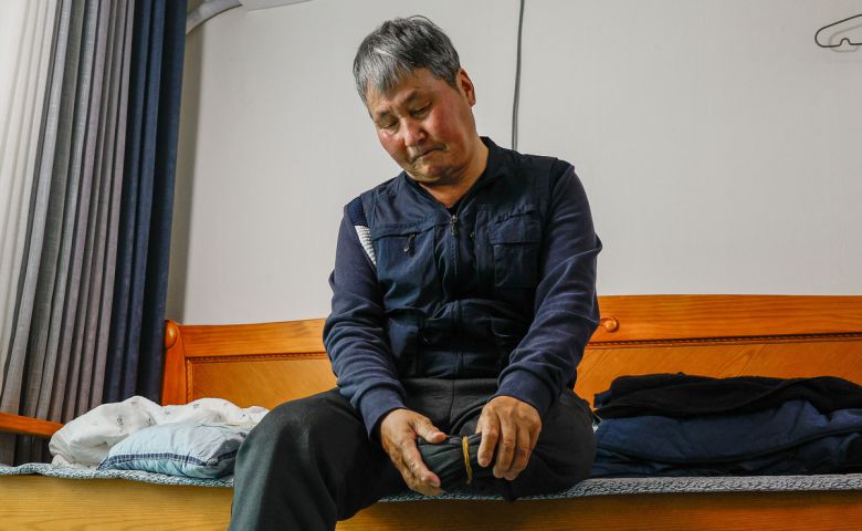 지난 10일 전북 전주시 완산구 평화동 자택에서 전직 환경미화원 김석곤(70)씨가 절단된 왼쪽 다리를 바라보고 있다. 김씨는 2년 전 새벽 음식물쓰레기 수거 업무 중 뺑소니 사고로 다리를 잃었다.   전주=최상수 기자