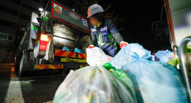 지난달 17일 밤 서울 금천구의 한 아파트 단지 분리수거장에서 환경미화원이 일반쓰레기 봉투를 청소차 적재함에 싣고 있다.  최상수 기자