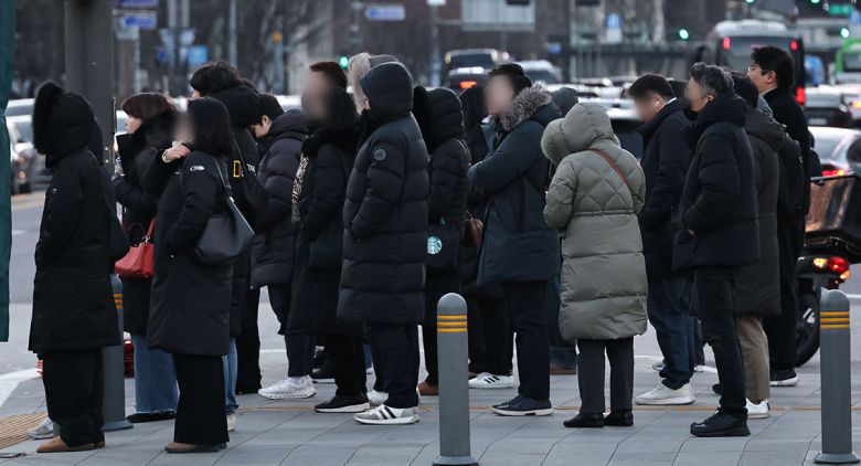 26일 서울 종로구 광화문 세종대로사거리에서 출근길 시민들이 횡단보도 신호를 기다리고 있다. 연합뉴스