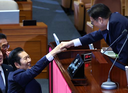 지난 24일 국회 본회의장에서 정보통신망법 개정안(일명 ‘허위조작정보근절법’)에 반대하는 야당의 무제한 토론(필리버스터)이 종결된 직후 더불어민주당 정청래 대표(왼쪽)와 우원식 국회의장이 활짝 웃으며 악수를 나누고 있다. 뉴시스