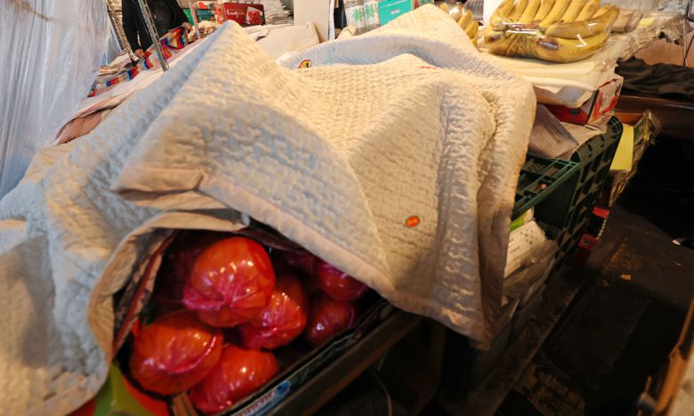 서울의 체감 온도가 영하 20도까지 떨어지는 등 전국 곳곳에 한파 특보가 발효 중인 26일 서울 송파구 가락농수산물종합도매시장의 한 점포에서 상인이 과일을 이불로 덮고 있다. 연합뉴스