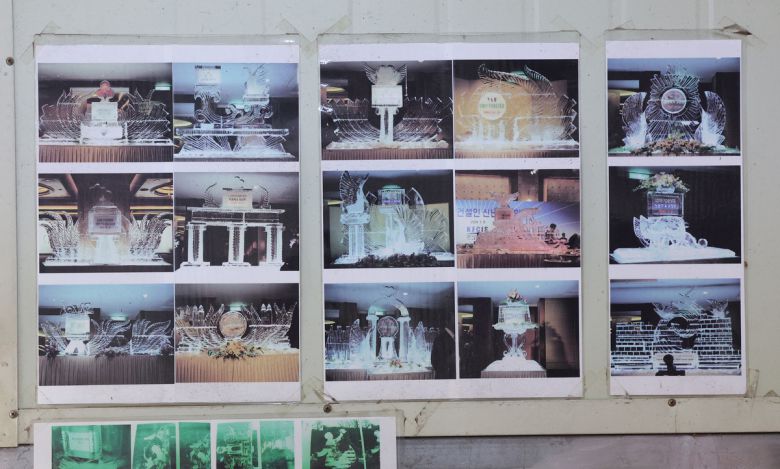 작업장 출입문에 예전에 만들었던 얼음조각 작품 사진들이 붙어 있다.