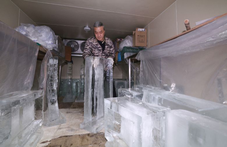 문성호 얼음조각가가 작업장 냉동창고에서 작업을 위해 얼음을 꺼내고 있다.