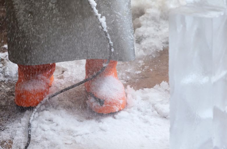 얼음 가루와 물, 전기톱에서 튄 얼음 파편이 바닥을 덮는다. 문성호 얼음조각가는 앞치마와 오렌지색 장화를 신고 그 위에 선다.