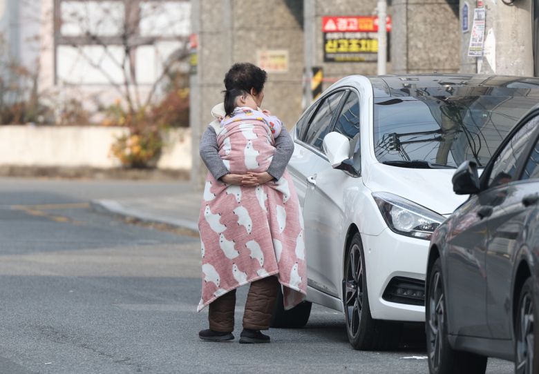 7일 오후 경남 밀양시 한 지역에서 한 시민이 손주를 업고 이동하고 있다. 연합뉴스