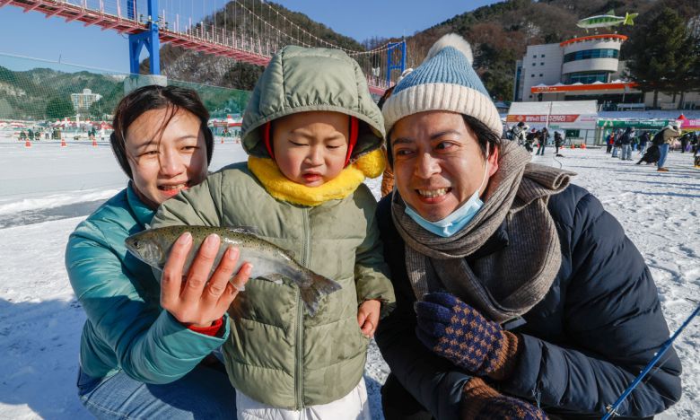 11일 강원 화천군 화천읍 화천천 일대에서 2026 얼음나라화천 산천어축제가 열린 가운데 행사장을 찾은 외국인 관광객 가족이 낚아올린 산천어를 들어보이고 있다.