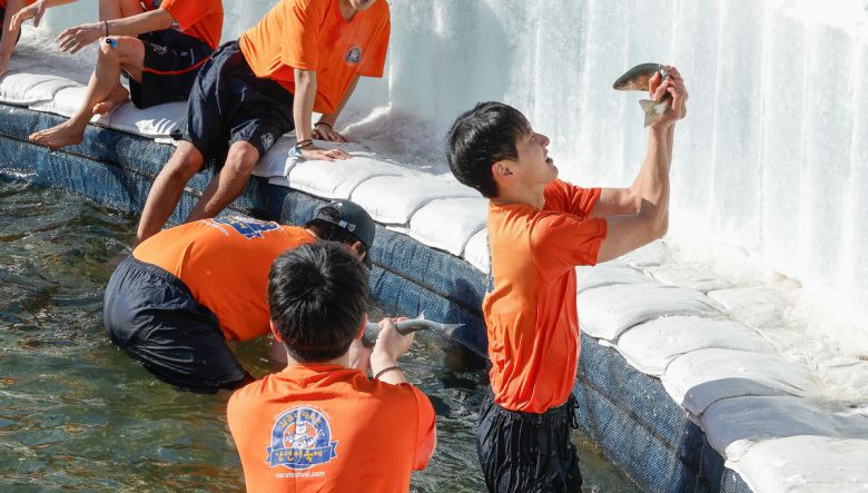 11일 강원 화천군 화천읍 화천천 일대에서 2026 얼음나라화천 산천어축제가 열린 가운데 행사장을 찾은 시민과 관광객들이 산천어 맨손 잡기 체험을 즐기고 있다.