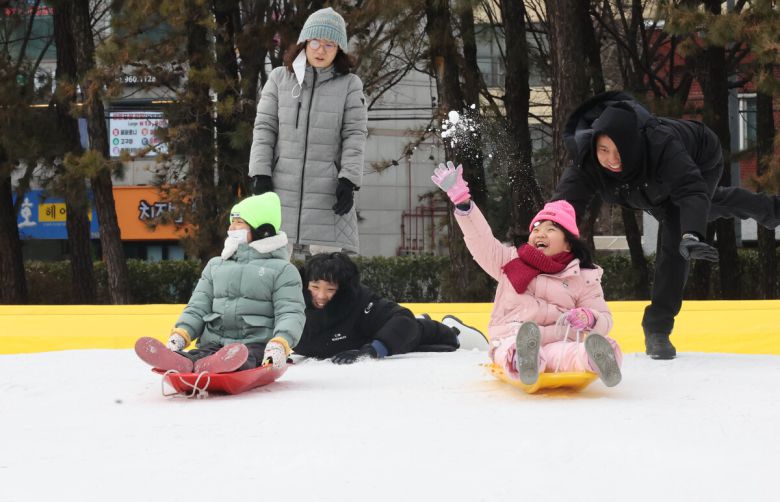 겨울 테마파크 2026 노원 눈썰매장 장애인 가족 초청행사가 열린 12일 서울 노원구 한국과학기술대학교에 마련된 행사장에서 참가자들이 눈썰매를 타고 있다.