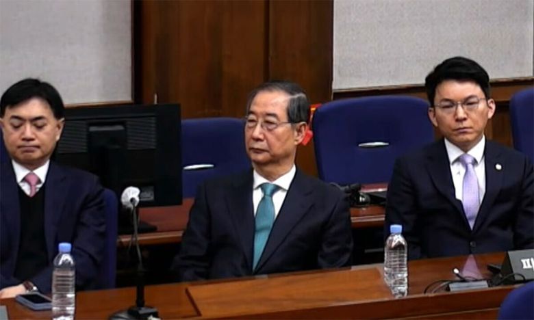 굳은 표정 한덕수 전 국무총리(왼쪽)가 21일 서울 서초구 서울중앙지법에서 굳은 표정으로 재판정을 응시하고 있다. 한 전 총리는 12·3 비상계엄 관련 내란에 가담한 혐의로 이날 1심에서 징역 23년을 선고받고 법정구속됐다. 생중계 화면 갈무리