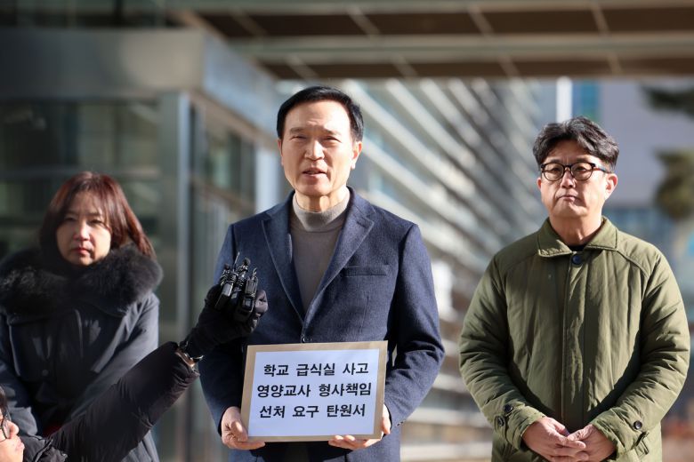 임태희 경기도교육감(가운데)이 21일 수원지검 앞에서 급식실 안전사고로 송치된 영양교사에 대한 선처를 요구하는 탄원서를 들고 인터뷰하고 있다. 경기도교육청 제공