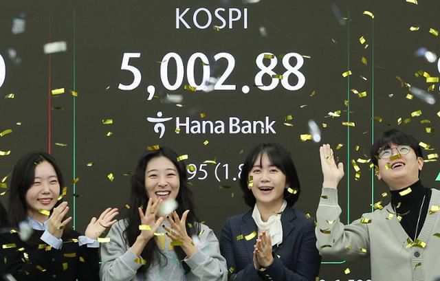 코스피지수가 사상 처음으로 장중 5000을 돌파한 22일 서울 을지로 하나은행 딜링룸에서 직원들이 신기록 달성을 축하하고 있다. 뉴스1