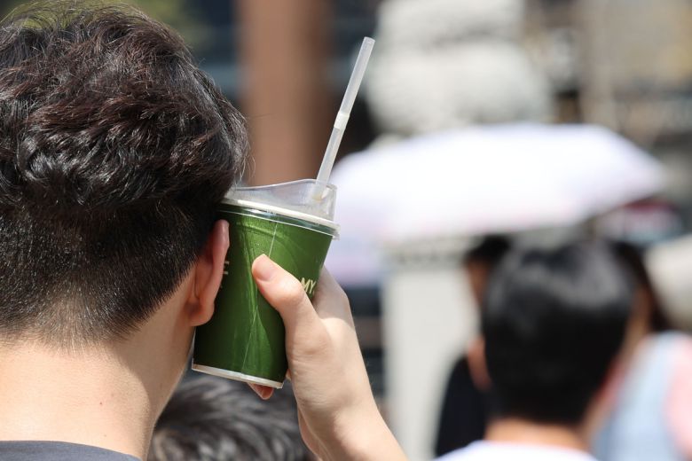 지난해 8월 전국 대부분 지역에 폭염특보가 발효된 가운데 서울 중구 청계천 인근에서 한 시민이 냉음료를 얼굴에 대고 있다. 뉴시스