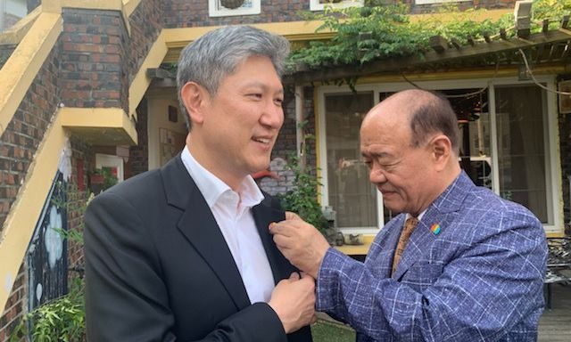 지난해 5월29일 노태우 전 대통령의 장남인 노재헌(왼쪽)씨의 옷깃에 박남선 광주 5·18 유족대표가 5·18 기념뱃지를 달아주는 모습. 사진=5·18 유족 제공