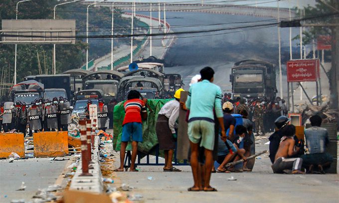 지난 14일(현지시간) 미얀마 양곤의 한링타랴르 마을에서 군사 쿠데타 반대 시위대가 집에서 만든 방패 뒤로 몸을 가리고 있다. AFP연합뉴스