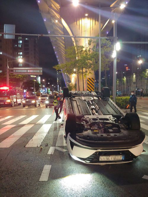 택시가 직진하던 승용차와 부딪힌 후 도로에 넘어져 있다.