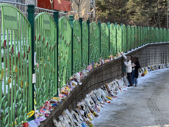 14일 오전 하늘양이 다니던 학교 앞에 시민들이 국화꽃과 과자, 장원영 포토카드, 추모메모 등을 남기며 애도하고 있다.