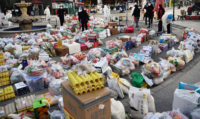 지난달 22일 이후 신종 코로나바이러스 감염증(코로나19) 확산에 따른 봉쇄 조치(주민 외출금지)가 지속되고 있는 중국 산시성 시안에서 12일 정부 관계자들과 자원봉사자들이 격리된 주택단지 앞에 배달된 생필품들을 주민들에게 전달하기 위해 분류작업을 하고 있다.   시안 신화=연합뉴스
