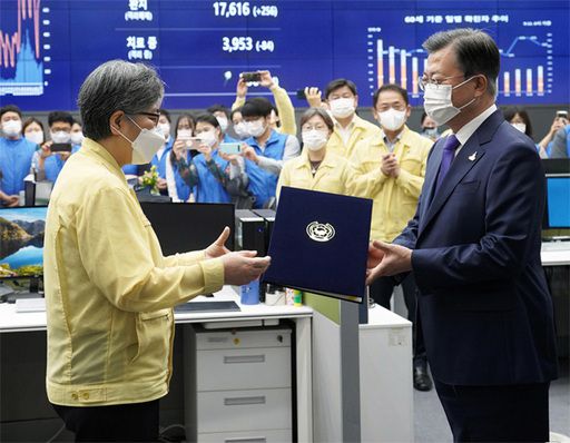 11일 문재인 대통령이 직접 질병관리본부 긴급상황센터를 찾아 정은경 초대 질병관리청장에게 임명장을 수여하고 있다. 그러나 당시 현장에서 사회적 거리 두기가 제대로 지켜지지 않았다는 지적이 나왔다. 청주=뉴시스