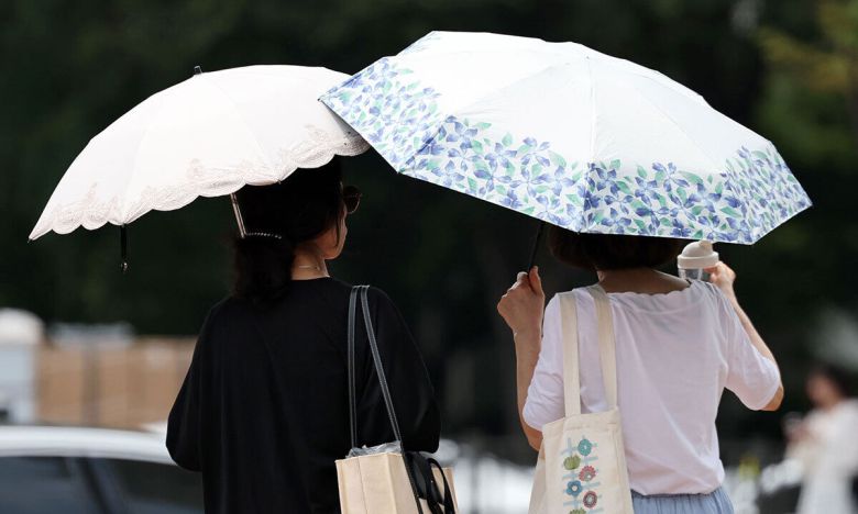 서울 시내의 한 거리에서 시민이 양산을 쓰고 이동하고 있다. 뉴시스