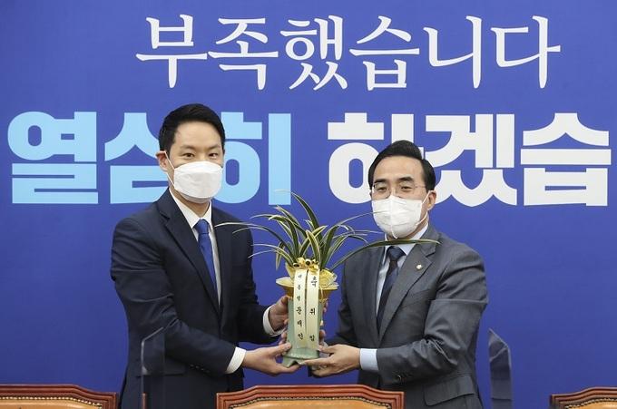 박홍근 더불어민주당 신임 원내대표(오른쪽)가 25일 서울 여의도 국회 원내대표 회의실에서 김한규 청와대 대통령비서실 정무비서관에게서 문재인 대통령의 축하 난(蘭)을 받고 있다. 연합뉴스