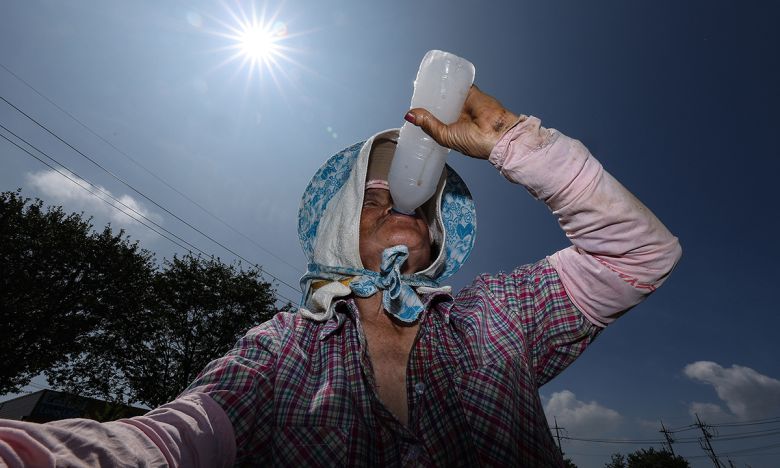 무더위가 계속되며 폭염특보가 발효 중인 2일 경북 고령군 다산면의 한 밭에서 파 모종을 심던 농민이 얼음물을 마시며 더위를 식히고 있다. 연합뉴스