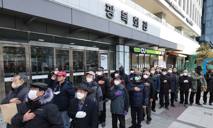 광복회 일부 회원들로 구성된 광복회개혁모임, 광복회정상화추진본부, 광복회재건 비상대책모임 등 관계자들이 16일 서울 영등포구 여의도 광복회관 앞에서 김원웅 광복회장의 구속 수사를 촉구하는 기자회견을 앞두고 국기에 경례하고 있다. 연합뉴스