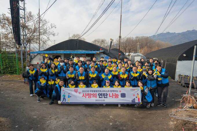 쿠팡풀필먼트서비스 임직원들이 경기도 과천시 꿀벌마을에서 ‘사랑의 연탄 나눔’ 봉사활동 기념사진을 촬영하고 있는 모습. 쿠팡풀필먼트서비스 제공